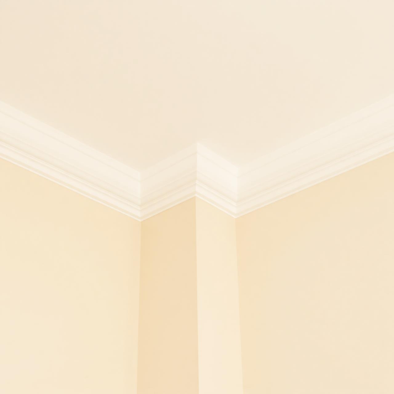 A crisp white ceiling meeting a cream wall at a clean cornice line