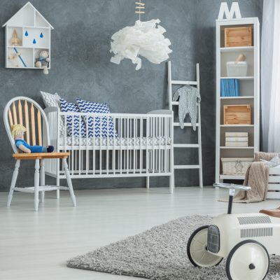 Grey boy room with white cot, bookcase and rug