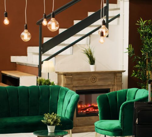 Hotel lounge area with luxurious couch, empty hotel reception and front desk space. Classy interior design with comfortable seats and marble floors indoors, stylish luxury resort.