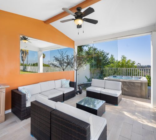 An outdoor patio with rattan furniture and a table under a covering in Hidden Hills, CA
